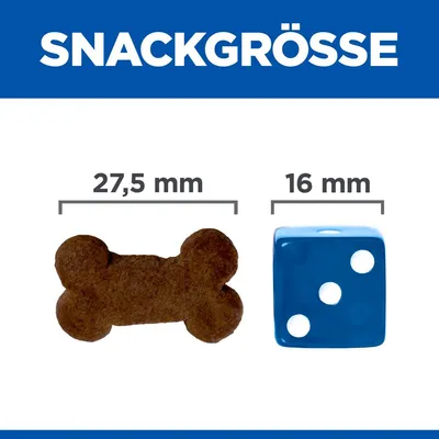 Comparaison de taille : friandise en forme d’os 27,5 mm à côté d’un dé bleu 16 mm. Texte allemand « SNACKGRÖSSE » visible en haut de l’image.