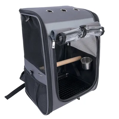 Sac de transport gris pour oiseaux avec perchoir en bois, gamelle en métal, grilles d’aération et poches latérales en filet. Ouverture frontale zippée avec volet transparent enroulable.