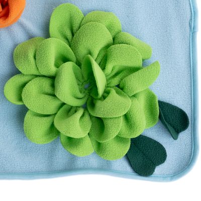 Lichtblau fleece met groen bloemenpatroon van stof, decoratieve bladeren aan de zijkant. Detailopname van het design.