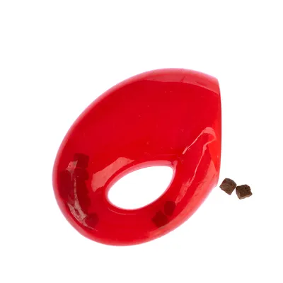 Rött leksak med oval öppning, fylld med små bruna godbitar. Lämplig för interaktiv lek och belöning.