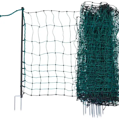 Clôture en filet vert avec piquets métalliques, partie déployée à gauche et rouleau de filet à droite, mailles carrées visibles.