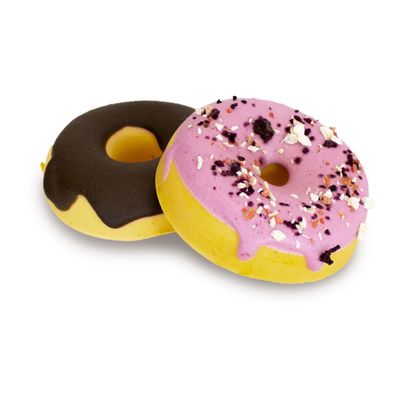 Два лакомства для собак в форме пончика: одно с шоколадной глазурью, другое с розовой глазурью и посыпкой.