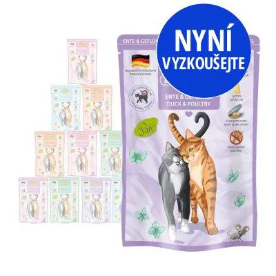 Balení krmiva pro kočky s nápisem ENTE & GEFLÜGEL, obrázek dvou koček, německá vlajka, modrý kruh s textem NYNÍ VYZKOUŠEJTE, více balení v pozadí.