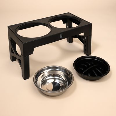 Zvýšená sada kŕmnej stanice s čiernym plastovým rámom, nerezovou miskou a čiernou miskou proti hltaniu. Výškovo nastaviteľná pre rôzne veľkosti.