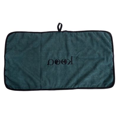 Groene mat met zwarte rand en lus, geborduurd met het opschrift 'kooa'.