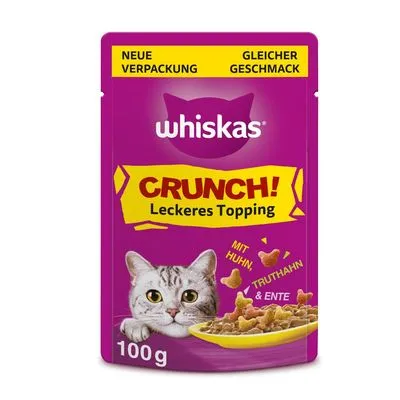 Whiskas Crunch! Leckeres Topping, 100 g. Tekst op verpakking: Neue Verpackung, Gleicher Geschmack, mit Huhn, Truthahn & Ente. Kat en voer zichtbaar. Tekst deels in het Duits.