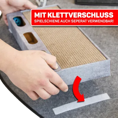Mit Klettverschluss. Spielschiene auch separat verwendbar! Hand zeigt, wie die Spielschiene mit Klettband befestigt wird.