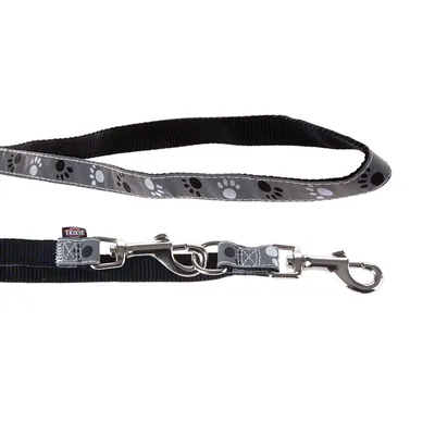 Lesă pentru câini Trixie din nailon negru cu model de lăbuțe gri și carabină metalică. Lesă pentru câini Trixie din nailon negru cu model de lăbuțe gri și carabină metalică.