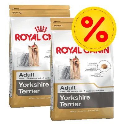 Twee zakken Royal Canin Adult Yorkshire Terrier hondenvoer, zichtbaar rasafbeelding en tekst: 'Over 10 months old'. Gele kortingssymbool met rood procentteken rechtsboven op de verpakking.
