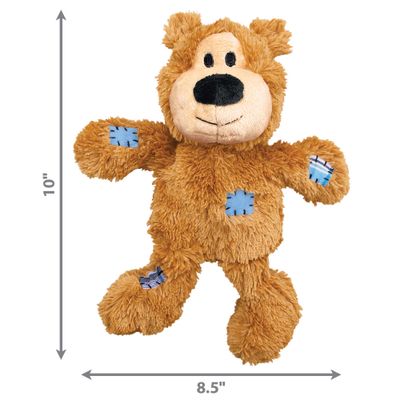 Brown plush toy in bear shape with embroidered details, including a blue and a checked patch on the legs.