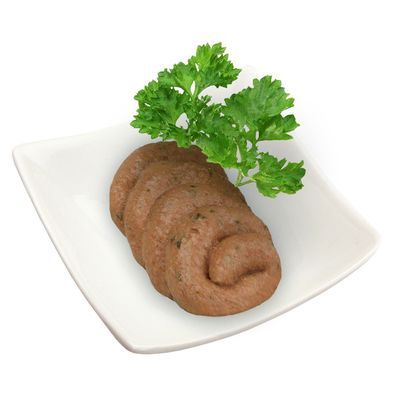 Plakjes bruin natvoer op een wit vierkant bord, gegarneerd met een takje verse peterselie. Geen merknaam of tekst zichtbaar.