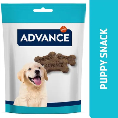ADVANCE puppy snack packaging with bone-shaped treats marked 'ADVANCE', image of a light-coloured puppy, and visible text 'PUPPY SNACK' on blue side panel.