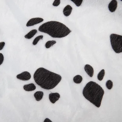 Primer plano de tela blanca con estampado de huellas negras.