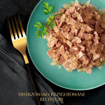 Talerz z mokrą karmą w galarecie i pietruszką, obok złoty widelec. Tekst: MISTRZOWSKO PRZYGOTOWANE RECEPTURY.