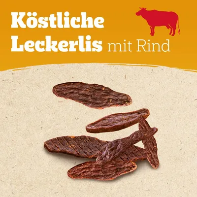 Köstliche Leckerlis mit Rind. Abgebildet sind mehrere Stücke getrockneter Rinder-Snacks auf beigem Hintergrund, rotes Kuhsymbol oben rechts.
