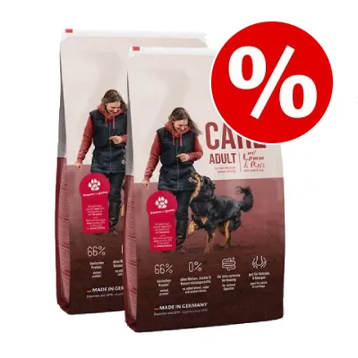 Två säckar hundfoder med texten 'CARE ADULT', synlig procent-symbol för rabatt, 66 % animaliskt protein, 0 % spannmål, MADE IN GERMANY. Bild på person och hund på förpackningen.
