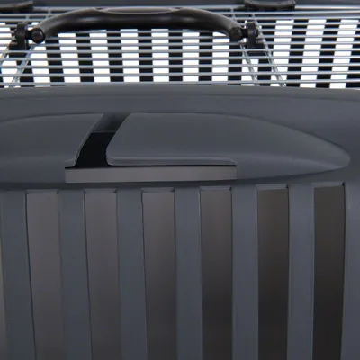 Detalje af transportkasse i grå plast med sort bærehåndtag og gitterlåg. Lodrette ventilationsåbninger synlige på siden.