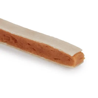 Közelkép egy hosszúkás snackről világos külsővel és puha, barna töltelékkel.
