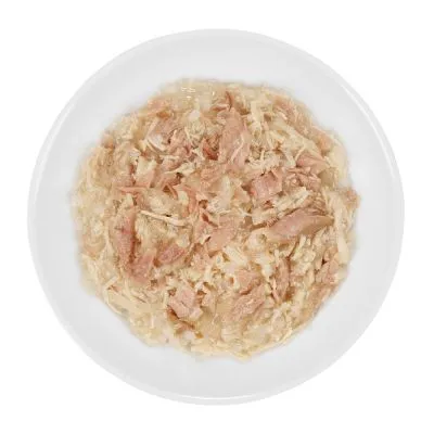 Cibo umido per animali in ciotola bianca, composto da pezzi sfilacciati di carne chiara immersi in gelatina trasparente. Nessun marchio o testo visibile.