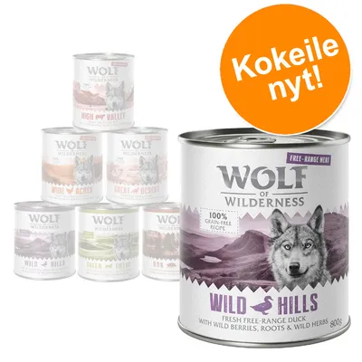 Wolf of Wilderness -koiran märkäruokapurkit, etualalla Wild Hills 800 g. Teksti: 100 % grain-free recipe, kokeile nyt! Makuja: High Valley, Wide Acres, Great Desert, Green Fields, Oak.