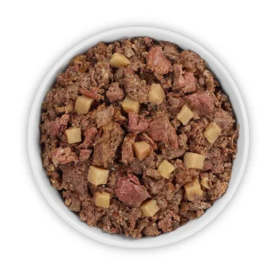 Primer plano de comida húmeda en un cuenco blanco, compuesta por trozos de carne y pequeños dados.