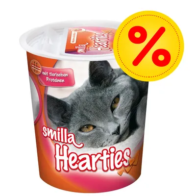 Envase de snacks para gatos Smilla Hearties, texto visible: 'mit tierischen Proteinen'. Símbolo de porcentaje en círculo amarillo indica oferta o descuento.
