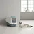 Gesloten kattenbak met pendeldeur in wit en blauw, daarnaast een liggende kat op een lichte houten vloer.