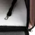 Intérieur d’un sac de transport pour animaux avec tapis en tissu blanc, sangle noire et mousqueton métallique visibles.