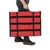 Sac de transport rectangulaire rouge avec poignées noires, porté à la main par une personne en jean et bottines noires. Matière textile visible.