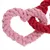 Плетена играчка за куче от розов и червен памучен въже, оформена като сърце.