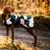 Dog wearing an outdoor jacket with a geometric pattern in white, green and yellow. 'rukka' brand visible on the jacket.
