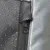 Närbild av en dragkedja med texten 'ZIP LON' på vadderat material med struktur.