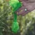 Mano che tiene un sacchetto verde in plastica annodato, utilizzato per la raccolta dei bisogni del cane. Nessun marchio o testo visibile sul sacchetto.