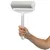 Hand holding a lint roller with silver handle and white frame, suitable for removing pet hair.