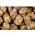 Close-up of compressed brown food pellets with visible flakes, showing texture and composition for product identification.