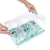Interactive toy with transparent lid and compartments, filled with small treats. Hands open the lid for filling or removal.