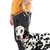 Dalmatian on a grey dog lead with brown leather details, held by a person in a yellow jumper and blue trousers.