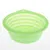 Green, foldable silicone bowl with ribbed sides and hanging hole.