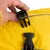 Primo piano di una chiusura a scatto nera su tessuto giallo, aperta da una mano.
