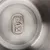 Gros plan sur le fond en acier inoxydable avec logo gravé 'Tiaki'.