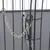 Prim-plan al unei cuști metalice cu lanț argintiu și carabinier pentru asigurarea ușii.
