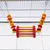 Colourful hanging wooden swing toy with beads and shapes attached to cage bars by metal chains, suitable for small animals or birds.