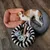Drei Hundebetten in verschiedenen Farben und Designs, mit Spielzeug wie Seil, Knochen und Ball. Ein Hund liegt im grauen Bett.