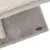 Szara, puszysta powierzchnia z logo Trixie na metalowej plakietce.