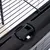 Close-up of a black locking mechanism on a metal grid cage, with visible operating symbols.