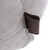 Detailaufnahme eines beige strukturierten Stoffes mit brauner Lederlasche.