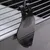Black plastic clip for attaching to metal grids, suitable for cages or enclosures.