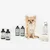 Kooa dog care products: four shampoo bottles and one automatic dispenser with liquid. Brand name visible on all products.
