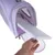 Main retirant un coussin blanc amovible d’un sac de transport violet avec panneaux en maille et fermeture éclair ouverte à l’avant.