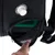 Sac de transport noir avec ouverture zippée, poche en filet et valve blanche visible. Intérieur vert partiellement visible. Main ouvrant la poche.